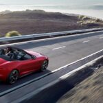 pre-owned red Jaguar convertible cruising